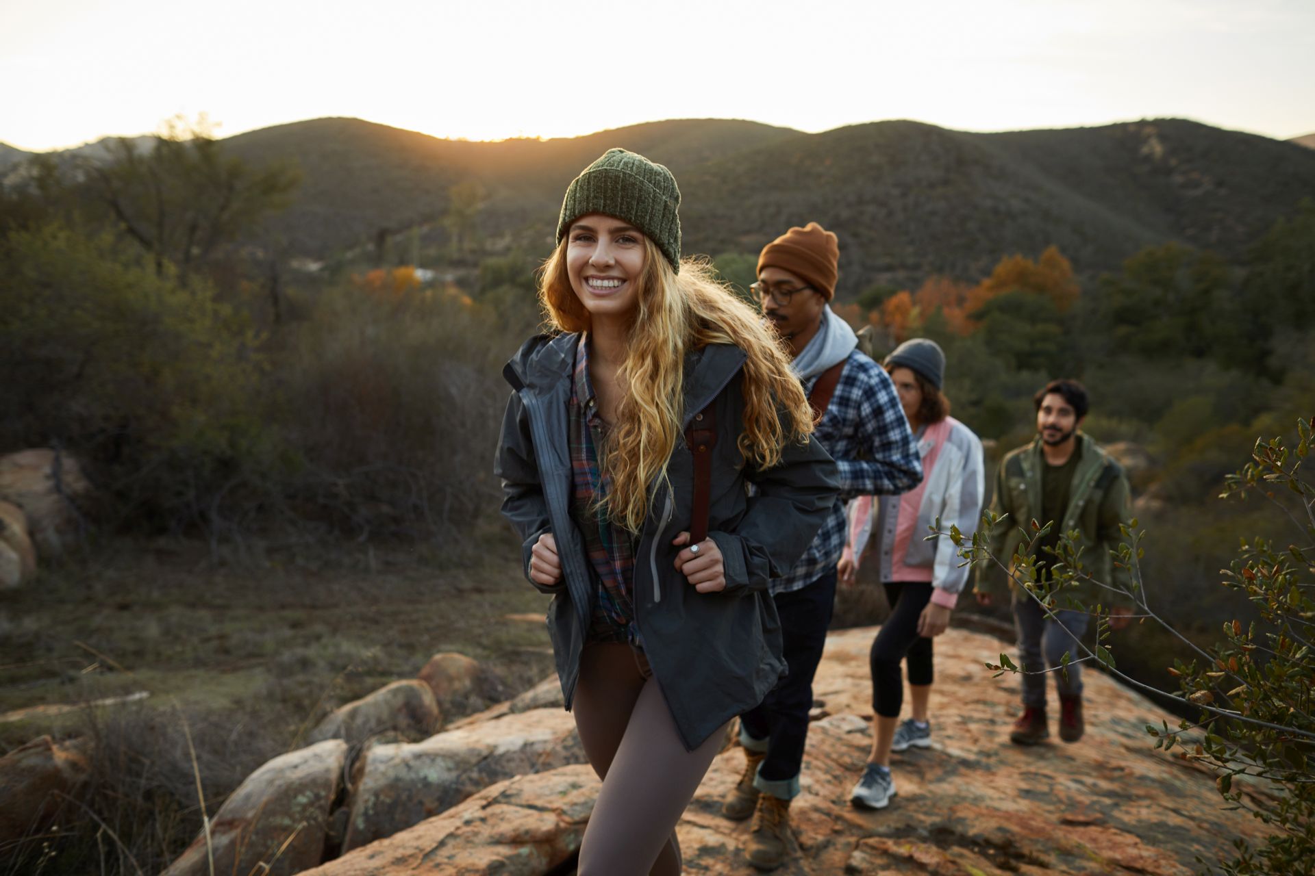 Wandernde Gruppe in den Bergen bei Sonnenuntergang
